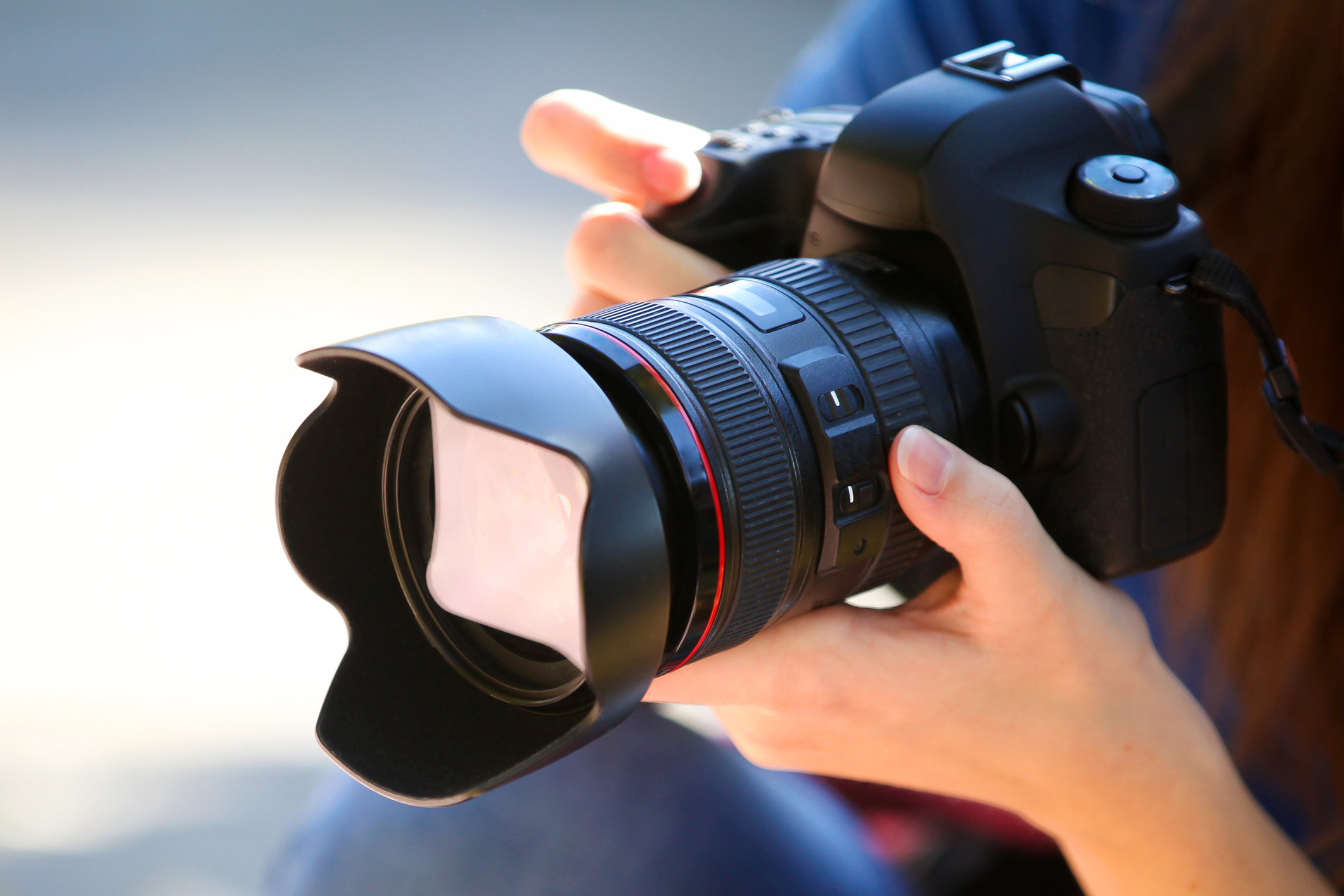 A Young Woman Holding a Full Frame Camera.